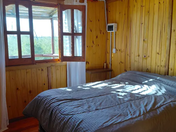 Dormitorio con cama matrimonial y ventana al exterior