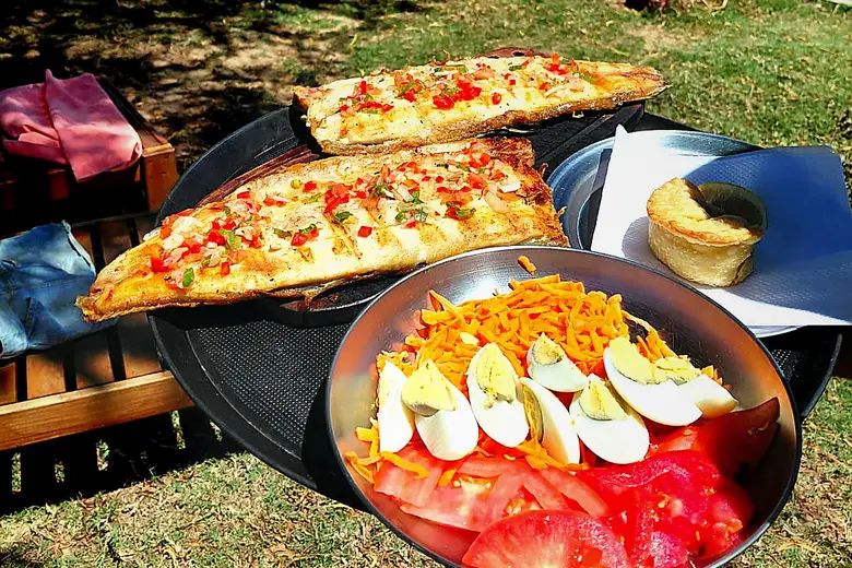 Pescado a la parrilla con ensalada, servido en el parque del Puerto
