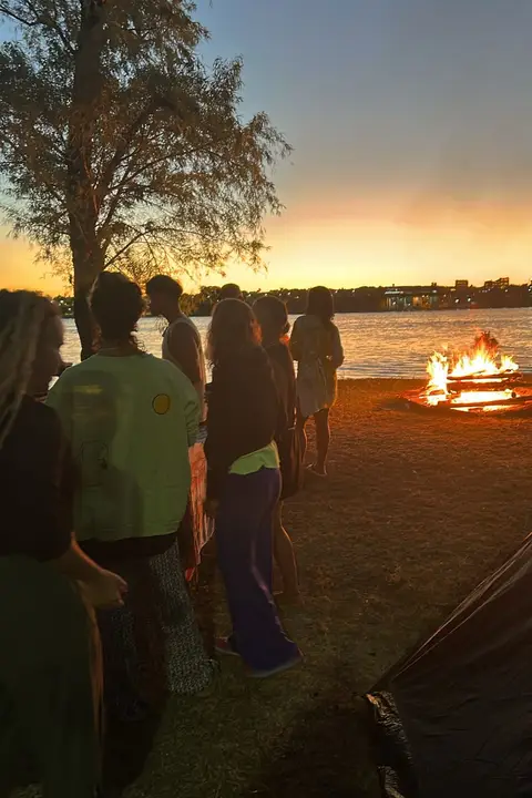 Atardecer sobre el río con un fogón en la costa